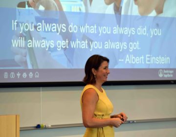 Monica Figuerido speaking in front of Albert Einstein quote: "If you always do what you always did, you will always get what you always got."