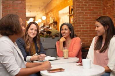 Four women sitting around a table having a conversation